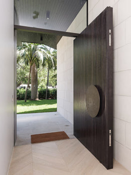 Grand Modern Dark Wood Pivot Door with Fluted Texture and Circular Handle