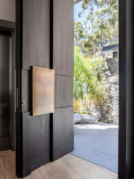 Designer Dark Oak Pivot Door Showcasing Vertical Accents and Statement Hardware